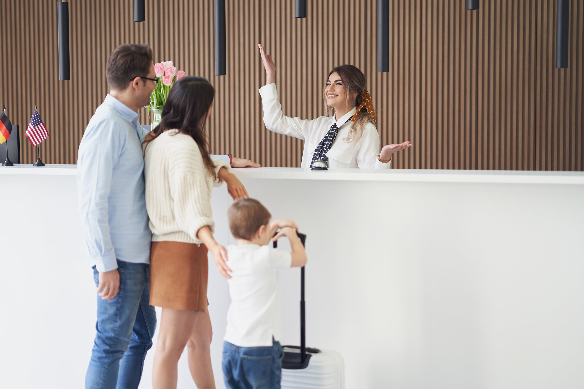 A family checking in at a hotel front desk